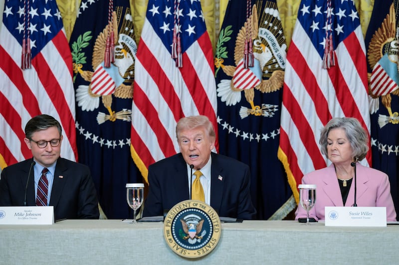 President Donald Trump, flanked by the Speaker of the House Mike Johnson (R-LA) and White House chief of staff Susie Wiles, speaks during a lunch with the Kennedy Center board members in the East Room of the White House in Washington, D.C., on March 16, 2026.