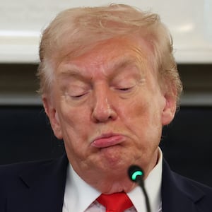 President Donald Trump reads a note during a roundtable discussion in the State Dining Room of the White House on October 08, 2025 in Washington, DC.