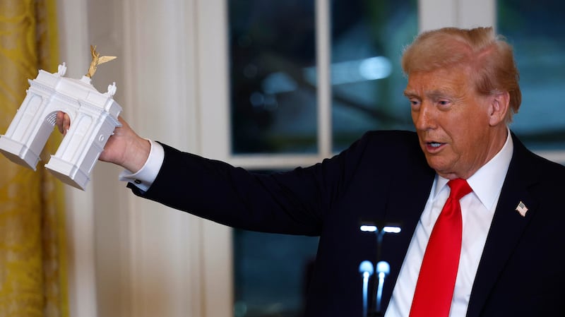 Trump holds a model of an arch