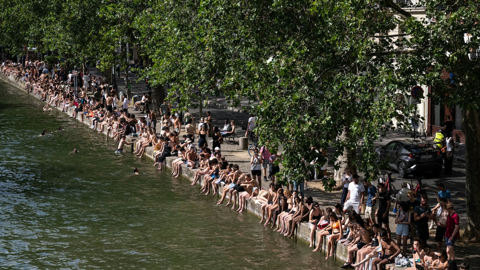 Swimmers sunbath on the banks of the Canal Saint-Martin as France experiences a heatwave in Paris on June 20, 2026.