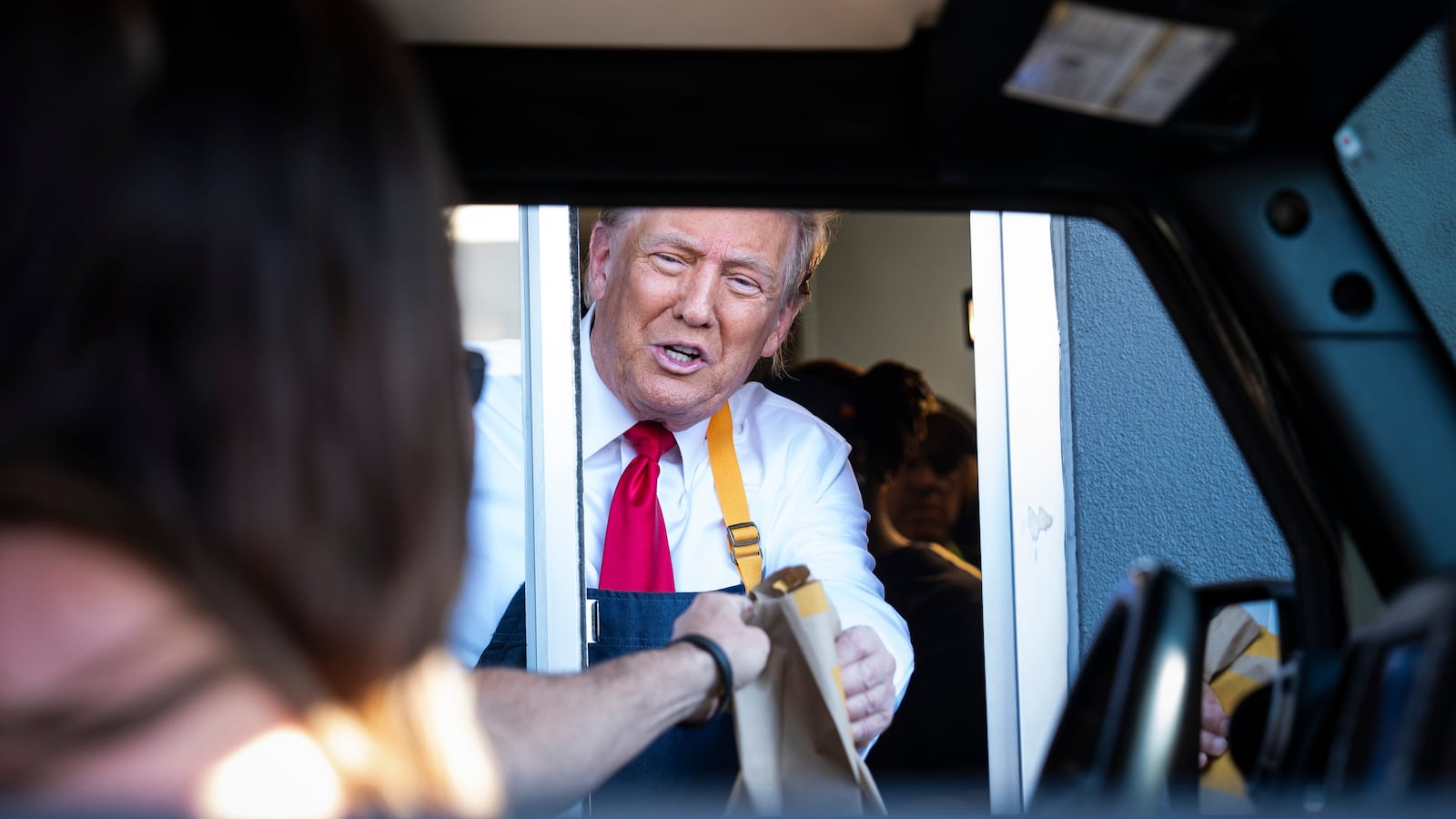 Feasterville-Trevose, PA - October 20 : Republican presidential nominee former President Donald Trump hands out food while standing at a drive-thru window during a campaign stop at a McDonald's in Feasterville-Trevose, PA on Sunday, Oct. 20, 2024. (Photo by Jabin Botsford/The Washington Post via Getty Images)