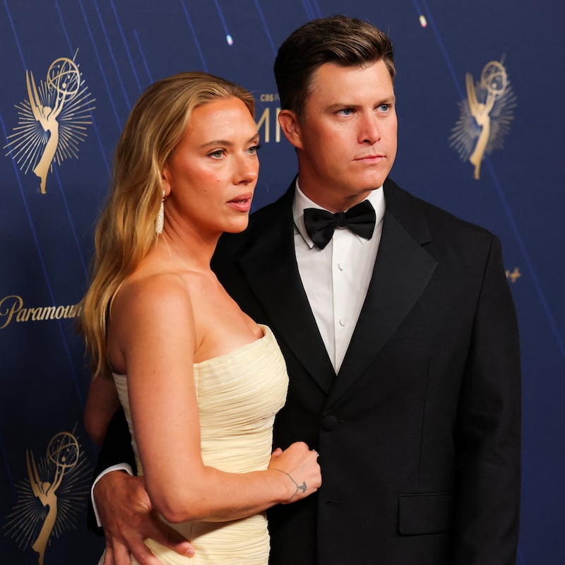 Scarlett Johansson and Colin Jost posing on the red carpet at the 77th Emmy Awards.
