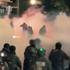 DHS officers and protestors in a sea of tear gas.