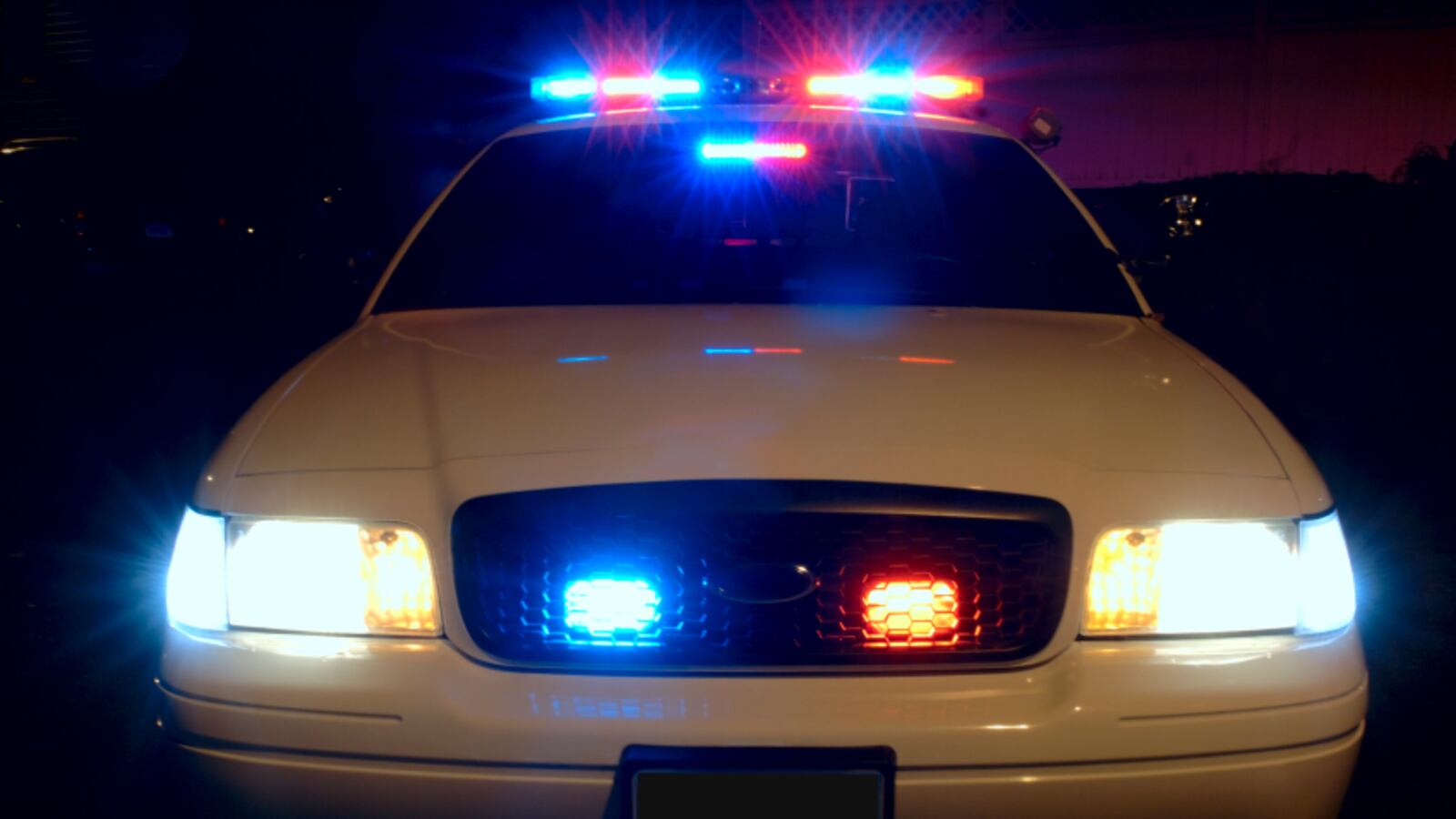 Police_car_with_emergency_lights_on_cnvcbm