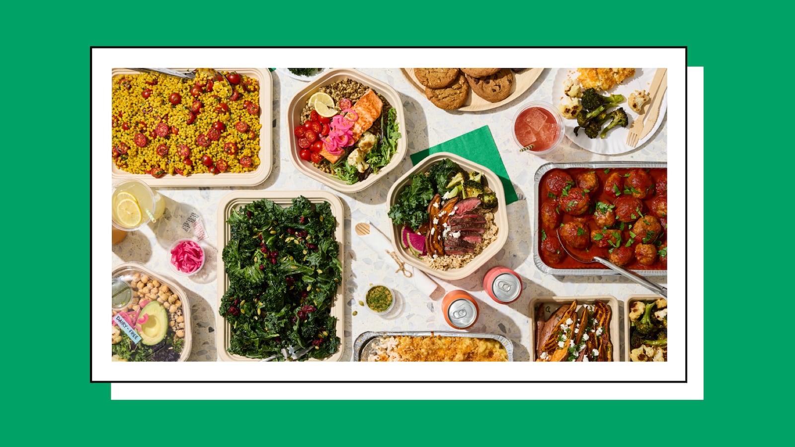 A spread of catered office meal containers featuring dishes including a kale salad, sliced steak bowl, meatballs in tomato sauce, roasted vegetables, salmon wi…A spread of catered office meal containers featuring dishes including a kale salad, sliced steak bowl, meatballs in tomato sauce, roasted vegetables, salmon with grain, couscous with tomatoes, and a dairy-free chickpea salad, arranged on a white surface against a green background.