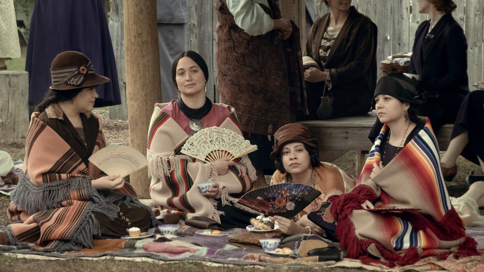 Lily Gladstone and the cast of Killers of the Flower Moon sitting in a still