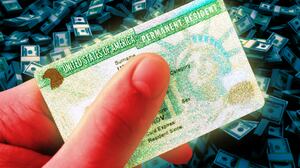 A photo illustration of a glowing gold US Green Card.
