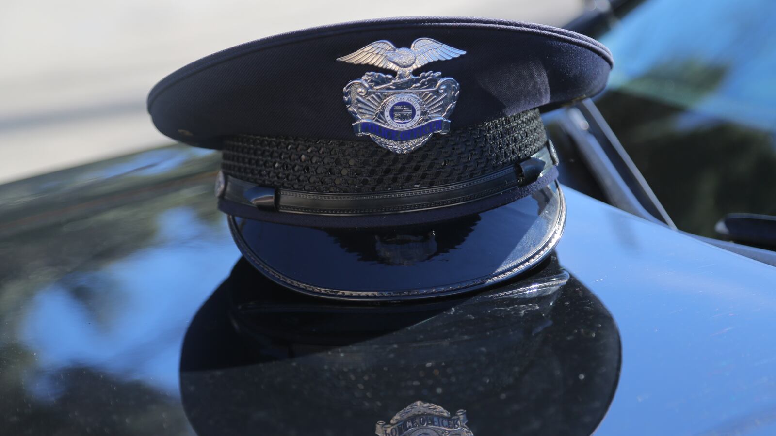 A Los Angeles Police Department (LAPD) officer's cap rests on the hood of a patrol vehicle in Los Angeles, California.