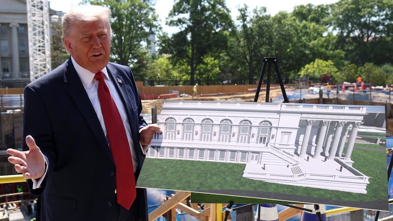 President Donald Trump shows images of the concept at the site of the ongoing construction of the planned White House ballroom in Washington, D.C., on May 19, 2026.