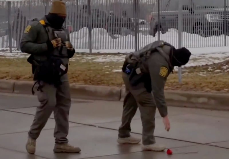 The agent picks up a rose from the street that had been part of the makeshift memorial to Good, then gives it to a female colleague.