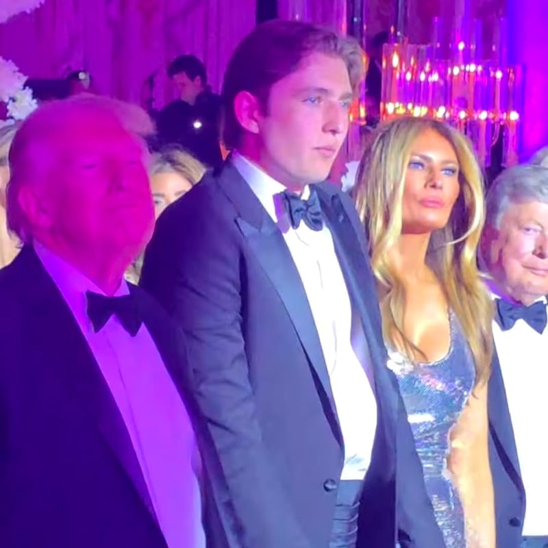Barron Trump stands between his president after, Donald, and FLOTUS's mother, Melania, at the New Year's party at Mar-a-Lago.