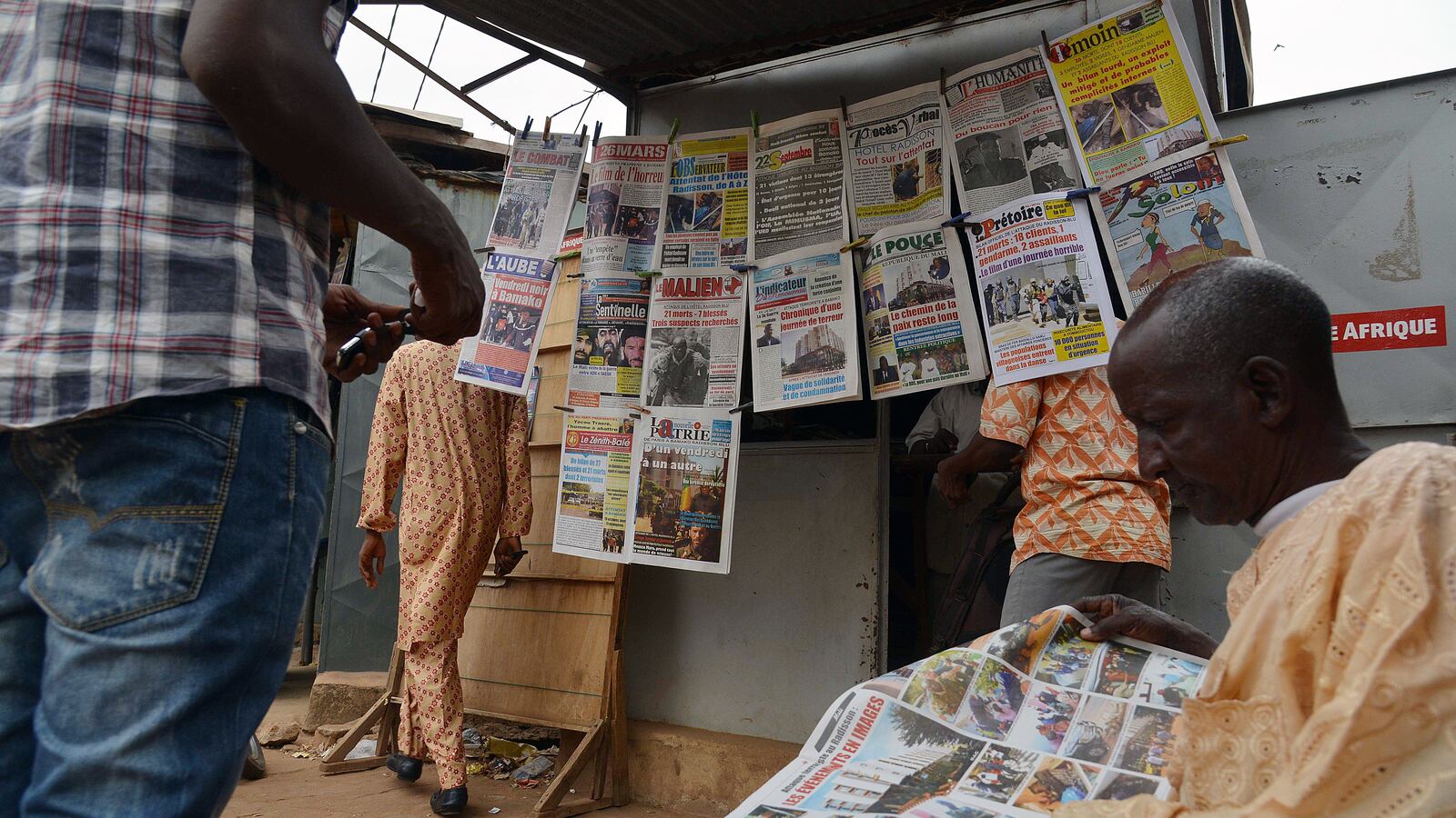A man reads a newspaper next to a newsstand in Bamako, Mali, on Nov. 23, 2015, three days after a deadly attack at the Radisson Blu hotel.