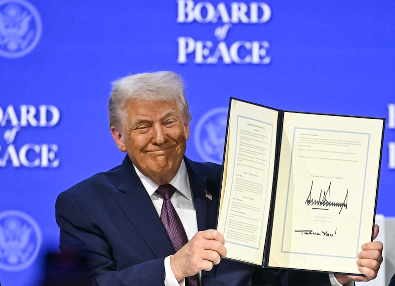 Donald Trump holds a signed founding charter at the "Board of Peace" meeting during the World Economic Forum (WEF) annual meeting in Davos on January 22, 2026.