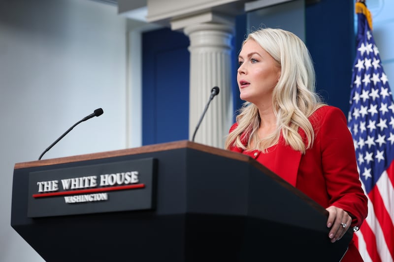 White House Press Secretary Karoline Leavitt, pictured at her news briefing on July 23, 2026, claimed the person seen at the podium is not the "real" her in a confessional video.