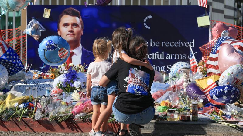 PHOENIX, ARIZONA - SEPTEMBER 16: (L-R) Braxley Lambertson, Huxley Lambertson, and their mother, Keslyn Lambertson, visit a makeshift memorial for Charlie Kirk outside of the headquarters of Turning Point USA on September 16, 2025, in Phoenix, Arizona. Kirk, the CEO and co-founder of Turning Point USA, was shot and killed on September 10th while speaking at an event for his "American Comeback Tour" at Utah Valley University. (Photo by Joe Raedle/Getty Images)