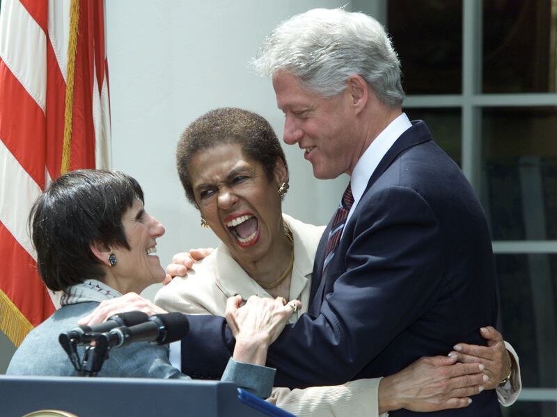 Norton and Rep. Rosa DeLauro (D-CT) embrace President Bill Clinton in 2000 after he urges the passage of the Equal Pay Act.