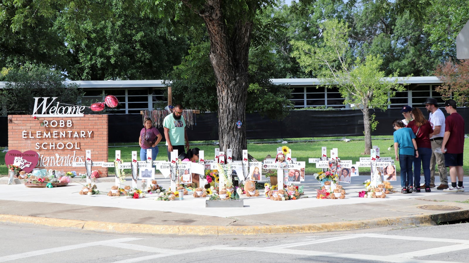 People visit a memorial for the 21 victims of a mass shooting at Robb Elementary School, one year after the shooting, in Uvalde, Texas.