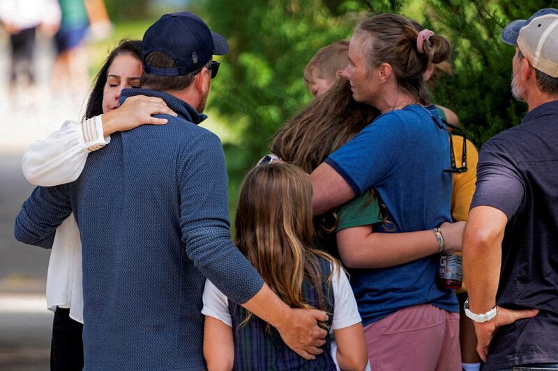 Families and loved ones reunite outside the police barricades after a shooting at Annunciation Church, which is also home to an elementary school, in Minneapolis, Minnesota, on Aug. 27, 2025.