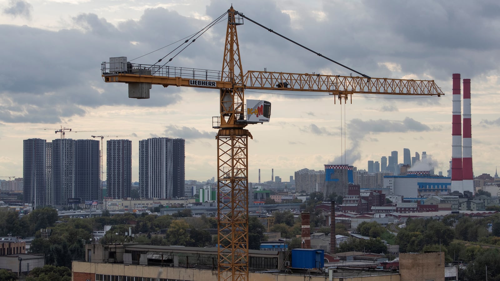 A view of a construction crane with city skyline in the background in Moscow.