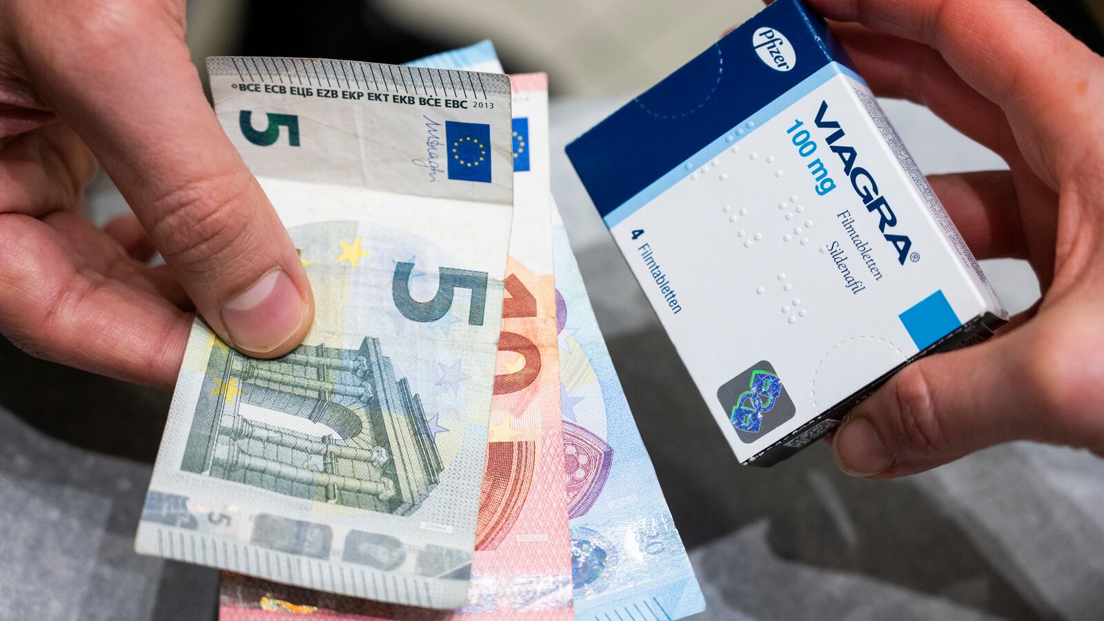 A man pays for Viagra tablets at a pharmacy.