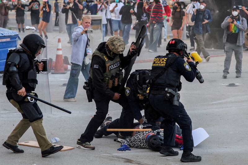 FILE PHOTO: Law enforcement officers detain a protester blocking the garage entrance of the Los Angeles Federal Building following multiple detentions by Immigration and Customs Enforcement (ICE), in downtown Los Angeles, California, U.S., June 6, 2025. REUTERS/Daniel Cole/File Photo