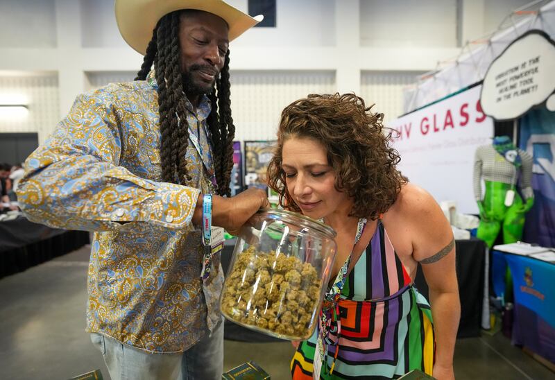 AUSTIN, TEXAS - SEPTEMBER 11: Cara Todkill smells cannabis flower from Warren Campbell, owner of W Squared Distribution in Houston, at CHAMPS Trade Show at the Palmer Events Center Thursday, Sept. 11, 2025.  The three-day business-to-business trade show focuses on the counterculture, smoke shop, and cannabis-related industries.