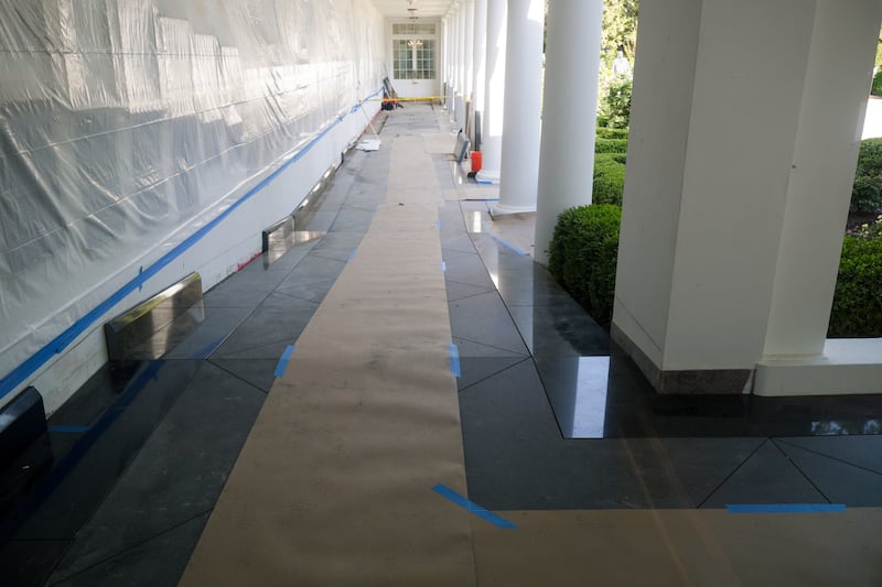 Flooring paper covers recently installed black granite tiles on the West Wing Colonnade