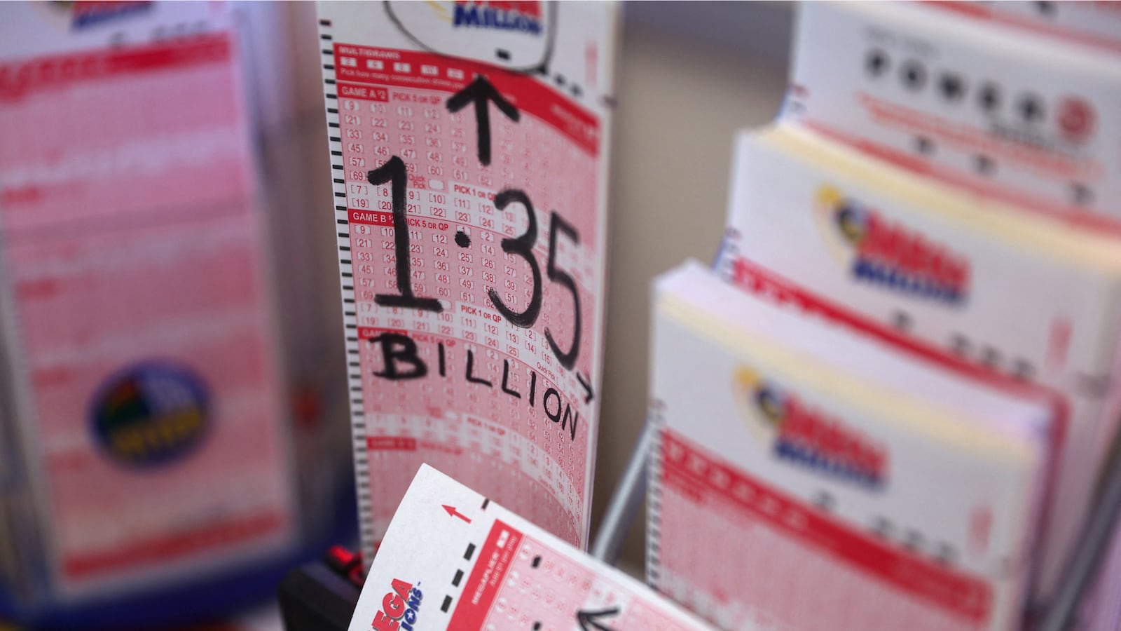 A photo of a batch of blank lottery tickets waiting to be filled out. On one of them, someone has written in black marker, “1.35 billion,” the jackpot.