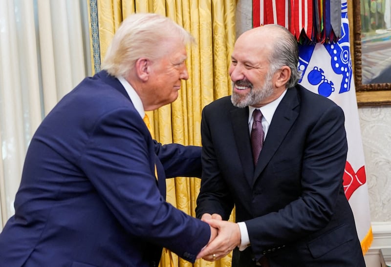 U.S. President Donald Trump shakes hands with Howard Lutnick, on the day Lutnick is sworn in as U.S. Commerce Secretary by Vice President JD Vance, in Washington, DC, U.S., February 21, 2025. REUTERS/Nathan Howard