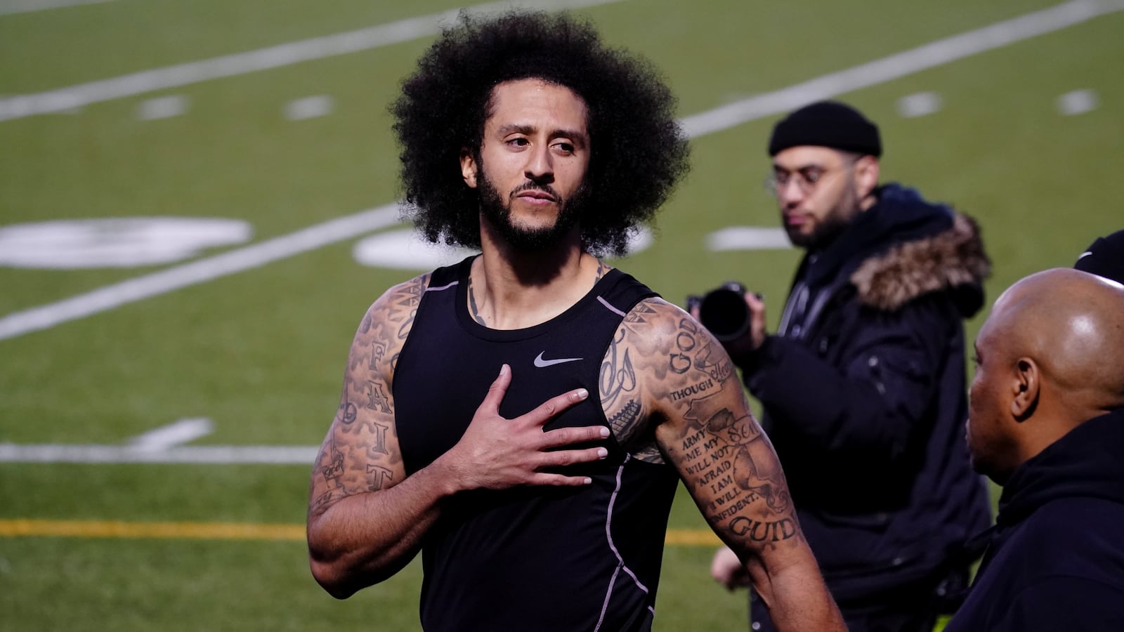 Colin Kaepernick puts his hand over his heart in response to a comment at a special training event created by Kaepernick.
