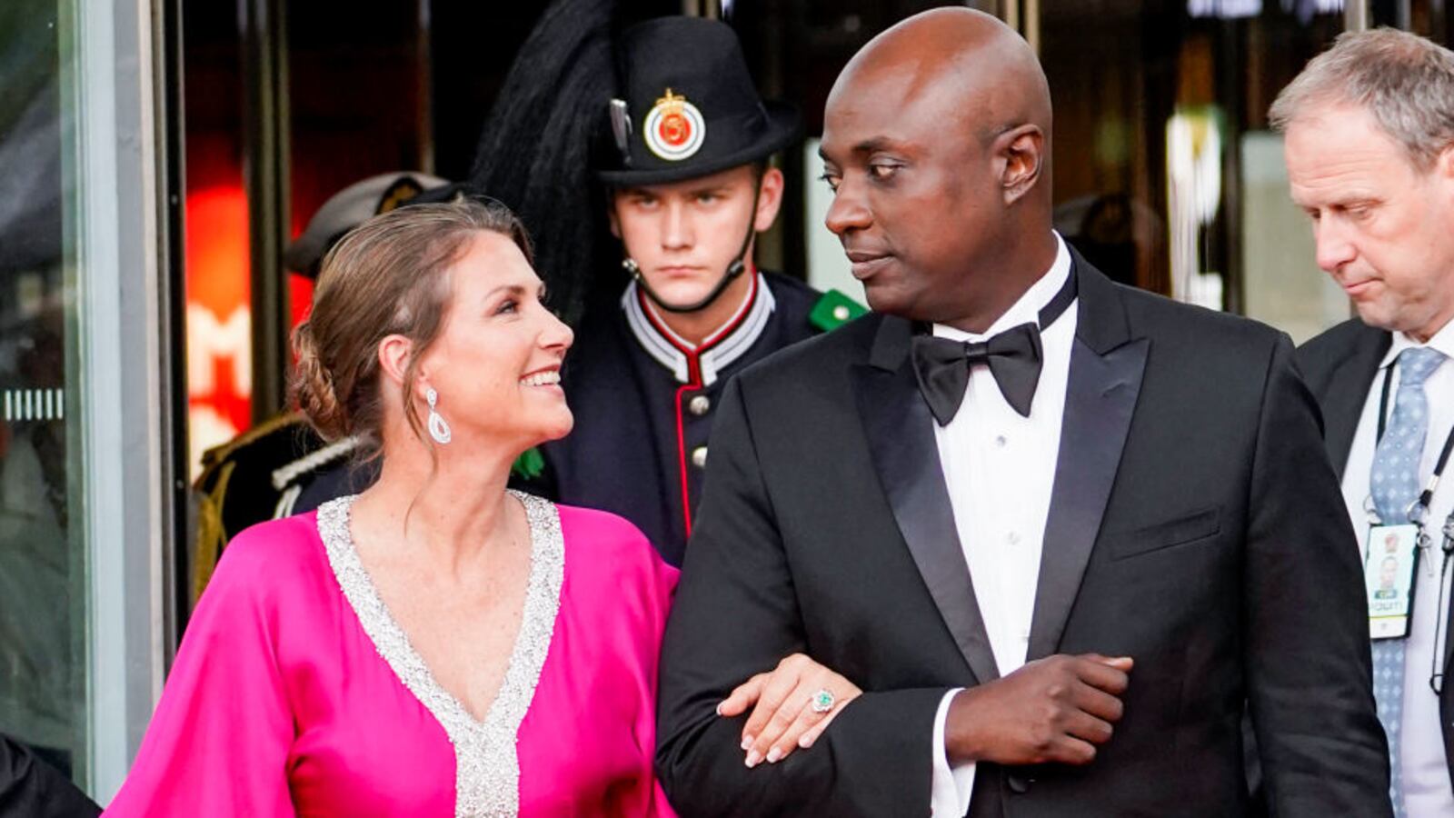 Princess Martha-Louise of Norway and Durek Verrett look at each other while walking.
