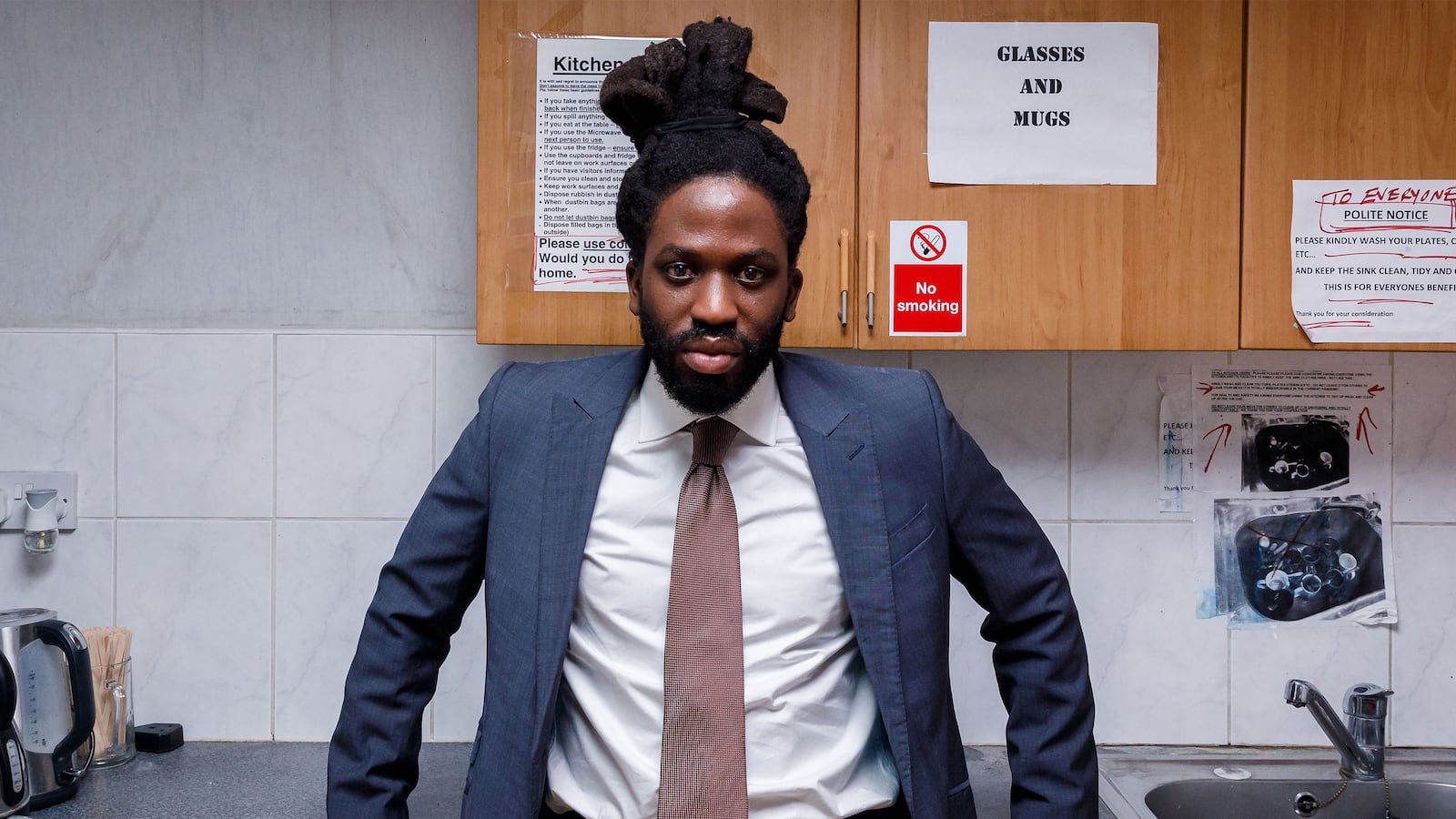 A still from 'Dreaming Whilst Black' that shows Adjani Salmon in a suit