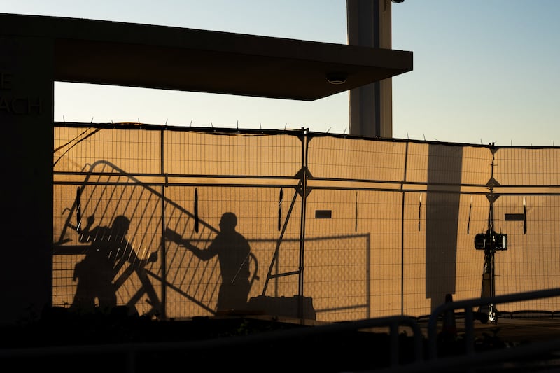 Crews cast shadows as they erect fencing outside the John F. Kennedy Memorial Center for the Performing Arts, a day after the Kennedy Center board voted to close the center for repairs, in Washington, D.C., U.S., September 16, 2026.