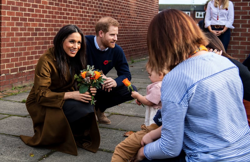 Bonnie and Maggie Emanuel give a posy of flowers to Britain’s Meghan, Duchess of Sussex, during a visit to Broom Farm Community Centre in Windsor, Britain, November 6, 2019.