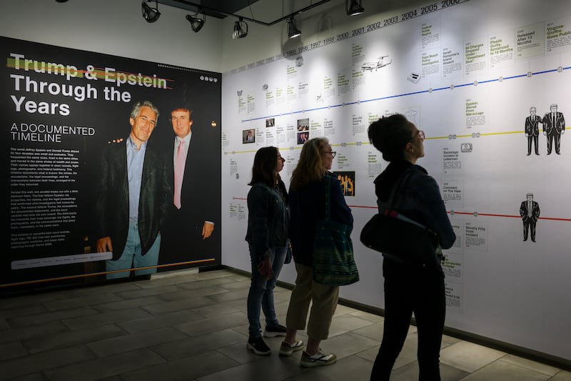 Visitors look at a timeline of events at the "Donald J. Trump and Jeffrey Epstein Memorial Reading Room", a tribute to the survivors and victims of Epstein's crimes, where 3.5 million pages, 3,437 bound volumes of the Epstein files are displayed in New York City on May 11, 2026. The pop-up exhibit created by the non-profit the Institute for Primary Facts will run through May 21. The Epstein saga has continued to roil American and British politics, as documents related to the expansive investigation into the financier's life have been released in previous months. (Photo by ANGELA WEISS / AFP via Getty Images)