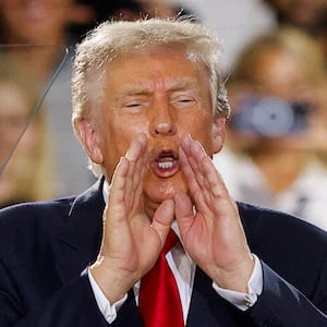 U.S. President Donald Trump puts his hands to his face, as he delivers remarks on the economy, at the General Motors Proving Ground in Milford, Michigan, U.S. July 27, 2026.  REUTERS/Carlos Osorio