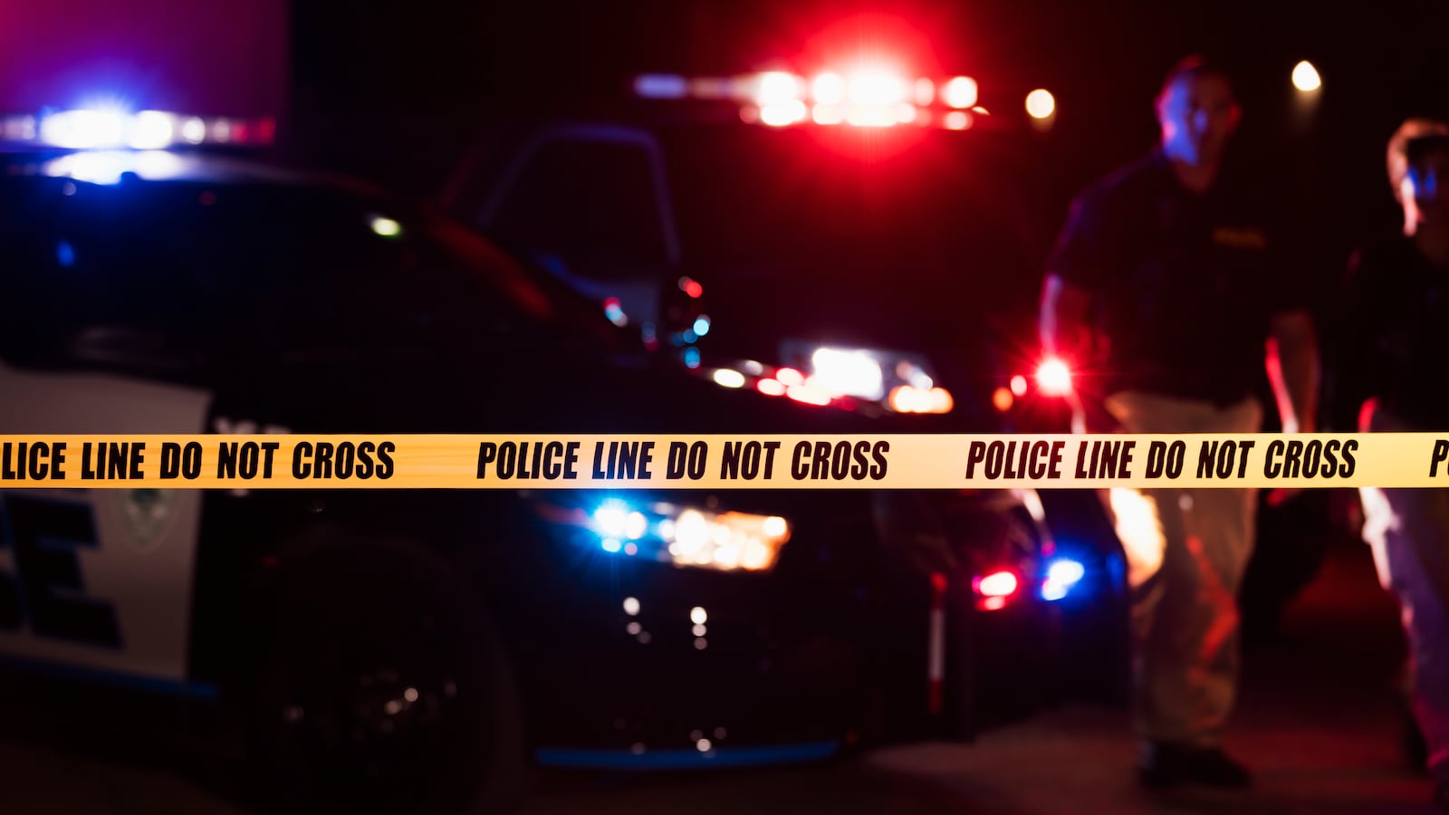 Police officers standing in front of patrol cars