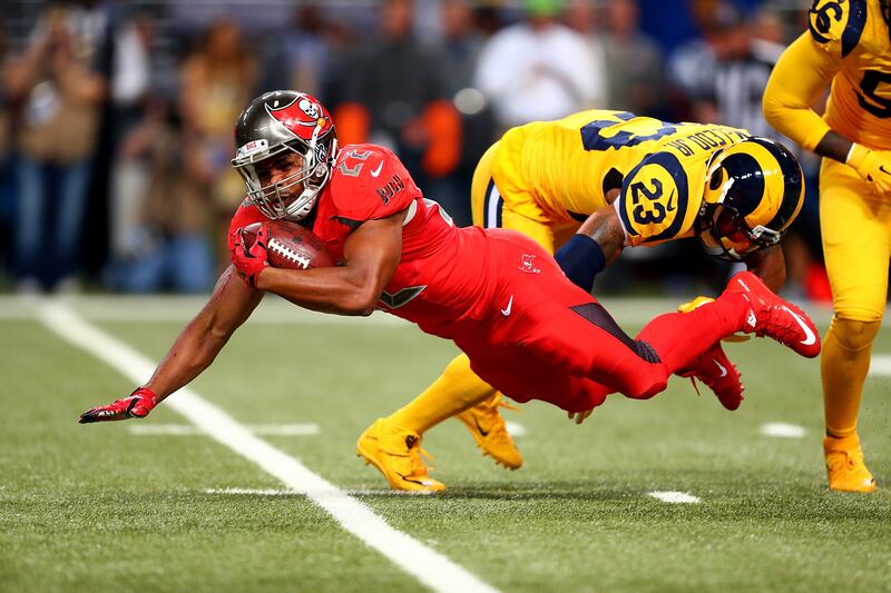 Doug Martin #22 of the Tampa Bay Buccaneers goes down after a hit from Rodney McLeod #23 of the St. Louis Rams in the second quarter at the Edward Jones Dome on December 17, 2015 in St. Louis, Missouri.