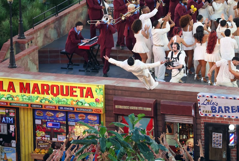 Bad Bunny performs onstage above a deli and barber shop during the Super Bowl.