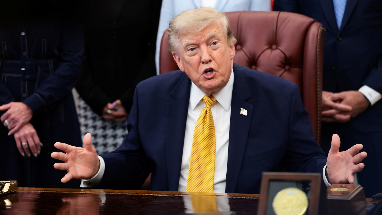 U.S. President Donald Trump answers questions from the media after signing an executive order establishing the President's Military Spouse Commission to be chaired by Jennifer Rauchet, wife of Secretary of Defense Pete Hegseth, in the Oval Office at the White House in Washington, D.C., U.S., August 3, 2026.