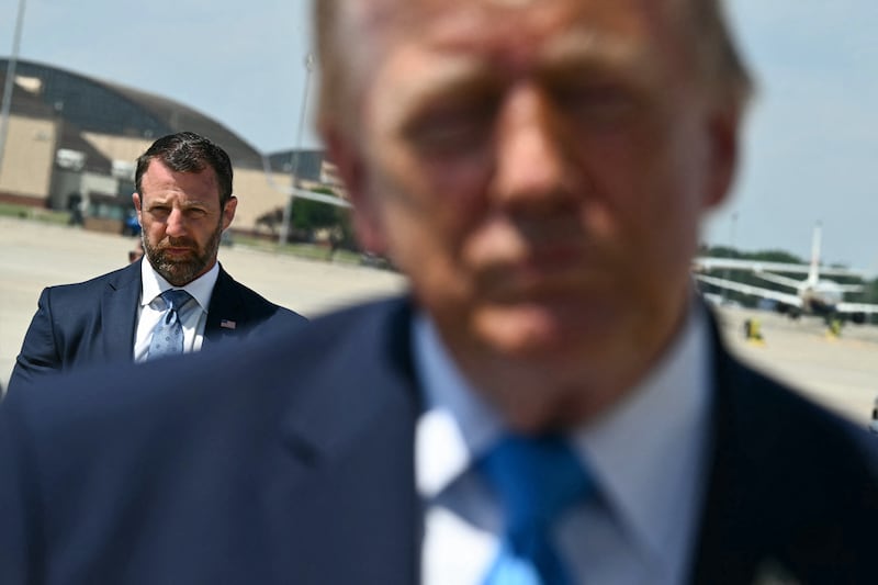 US Secretary of Homeland Security Markwayne Mullin looks on as President Donald Trump speaks to reporters after stepping off Air Force One.