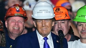Members of "Steelworkers for Trump" pose with former US President and Republican presidential candidate Donald Trump after they gifted him a hard hat during a campaign rally at Arnold Palmer Regional Airport in Latrobe, Pennsylvania, October 19, 2024. (Photo by Jim WATSON / AFP) (Photo by JIM WATSON/AFP via Getty Images)