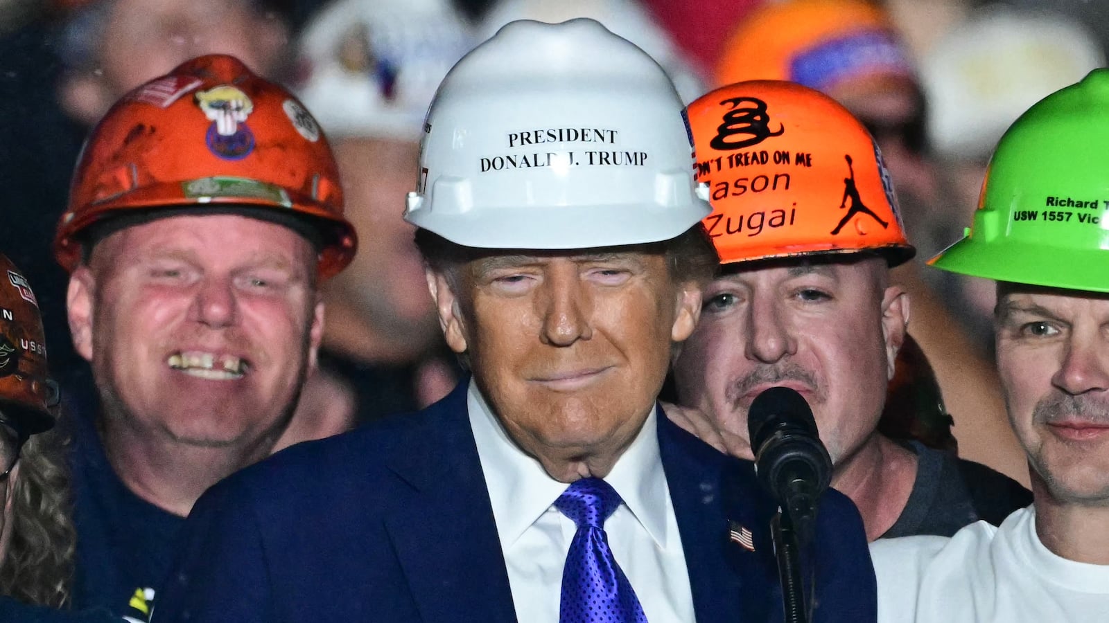 Members of "Steelworkers for Trump" pose with former US President and Republican presidential candidate Donald Trump after they gifted him a hard hat during a campaign rally at Arnold Palmer Regional Airport in Latrobe, Pennsylvania, October 19, 2024. (Photo by Jim WATSON / AFP) (Photo by JIM WATSON/AFP via Getty Images)