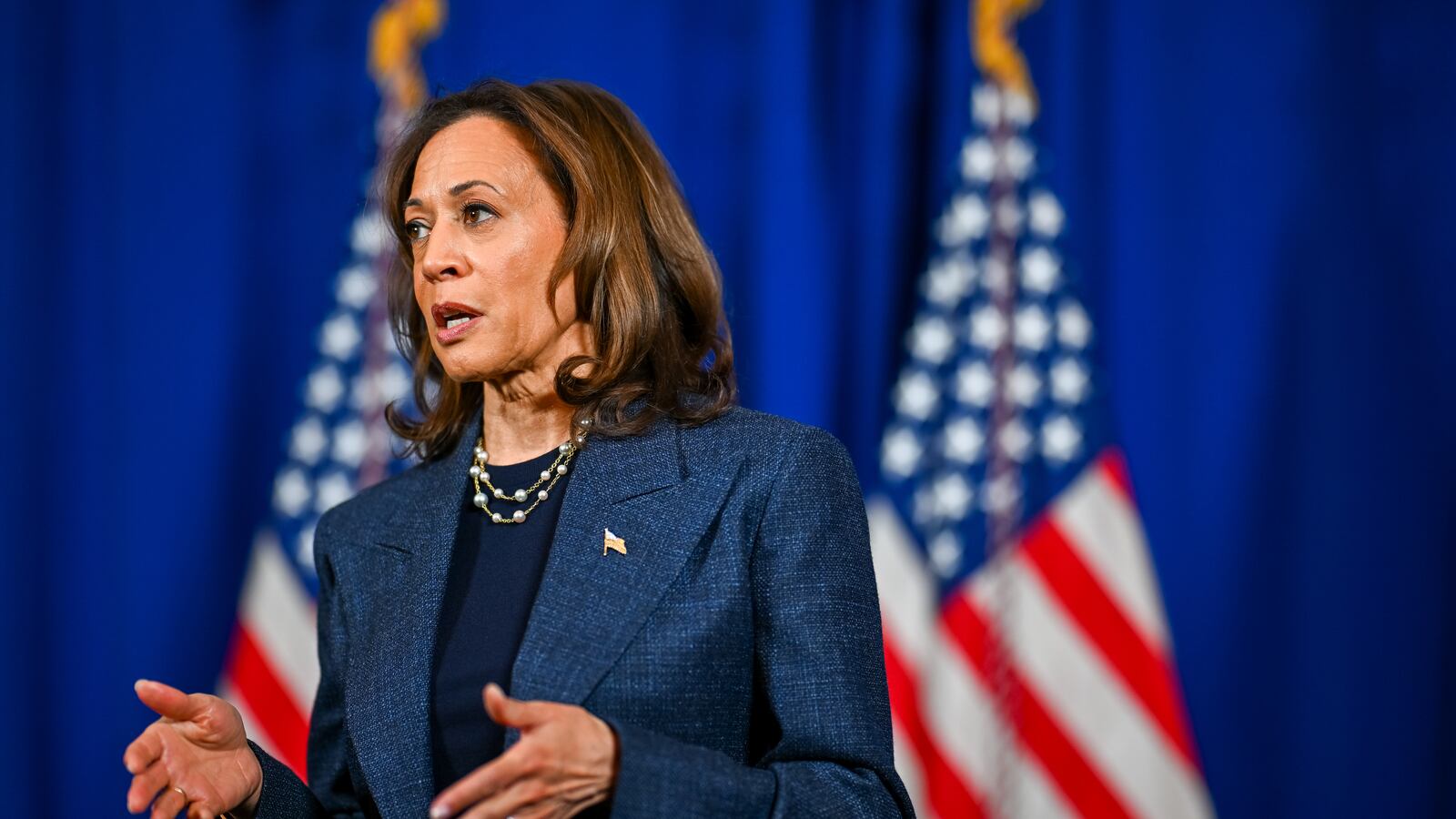 Kamala Harris looks on.