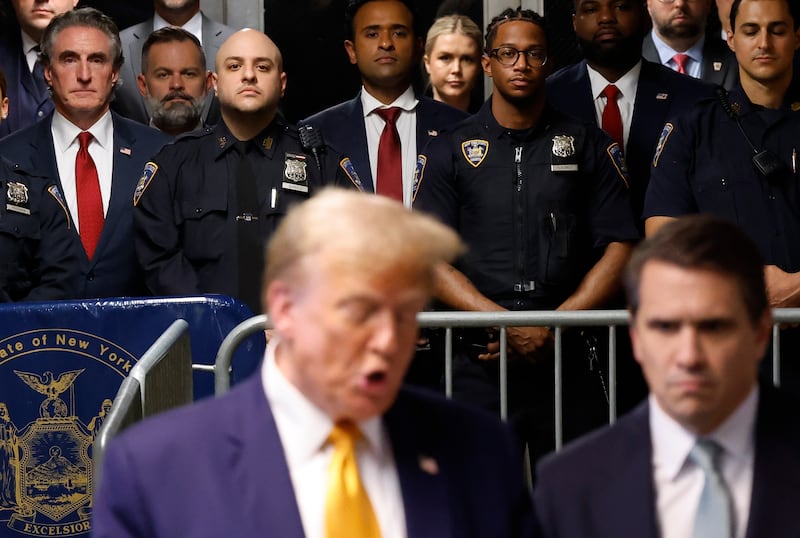 North Dakota Governor Doug Burgum, former Presidential candidate Vivek Ramaswamy, Rep. Byron Donalds (R-FL) listen as former U.S. President Donald Trump speaks to the media.