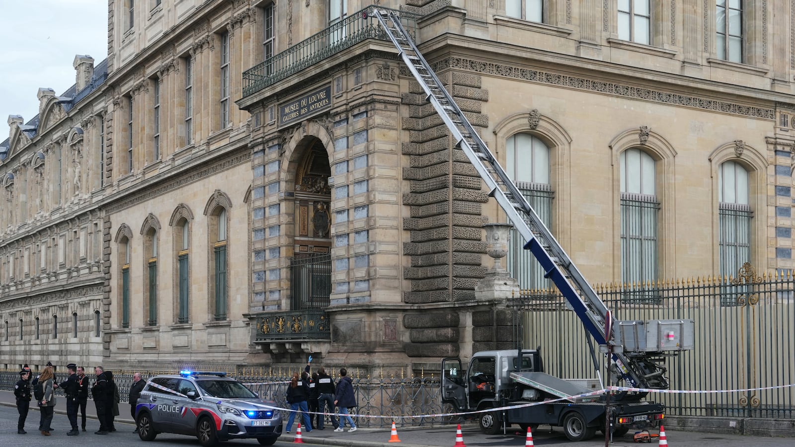 French police officers stand next to a furniture elevator used by robbers to enter the Louvre Museum