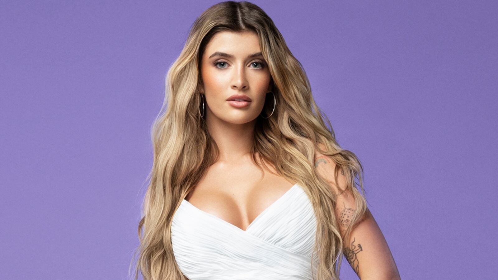 Sami Sheen in a white calf-length low-cut dress with bare shoulders.