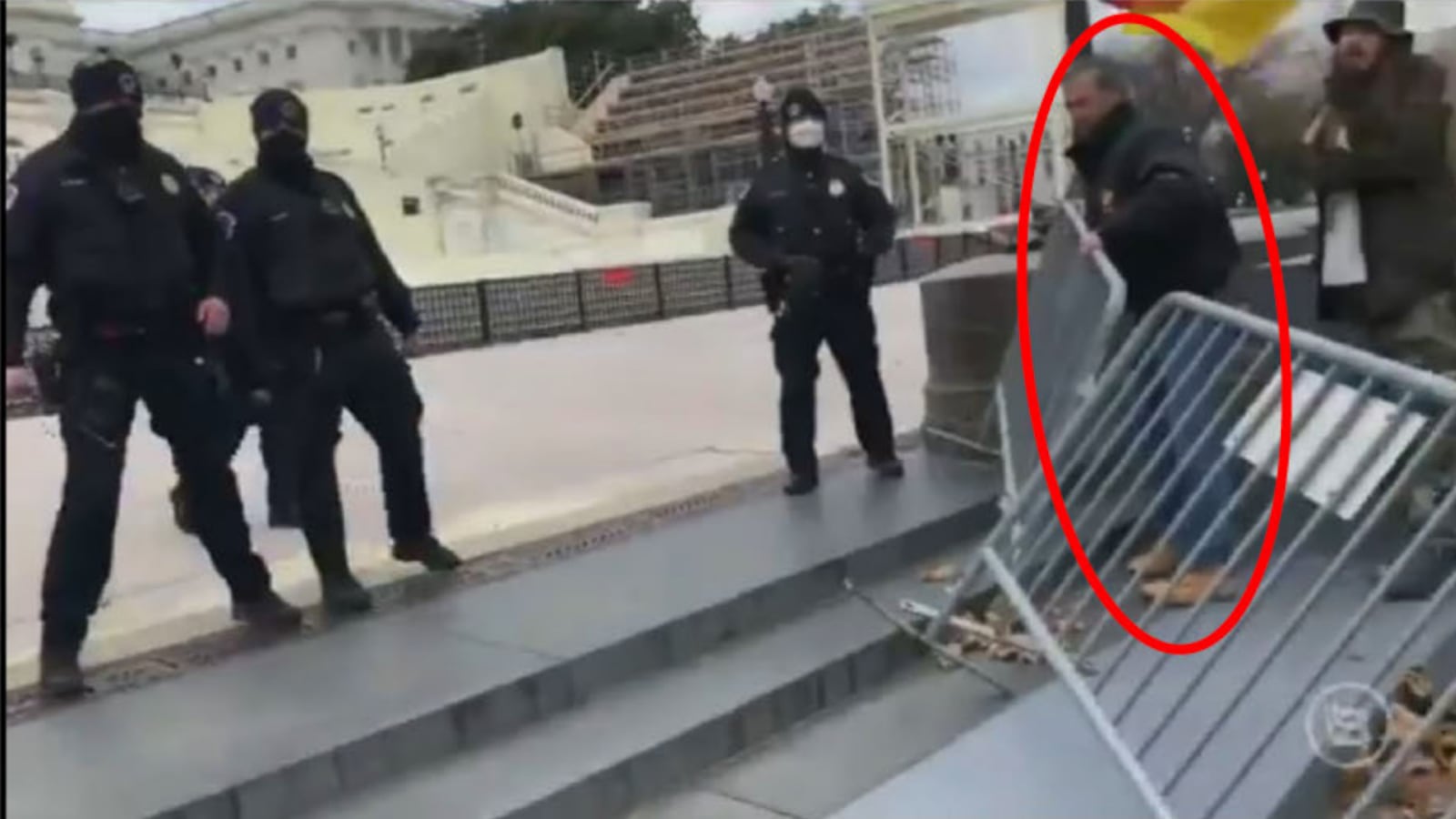 Accused Jan. 6 rioter Michael Daniele overcoming a police barricade at the Capitol