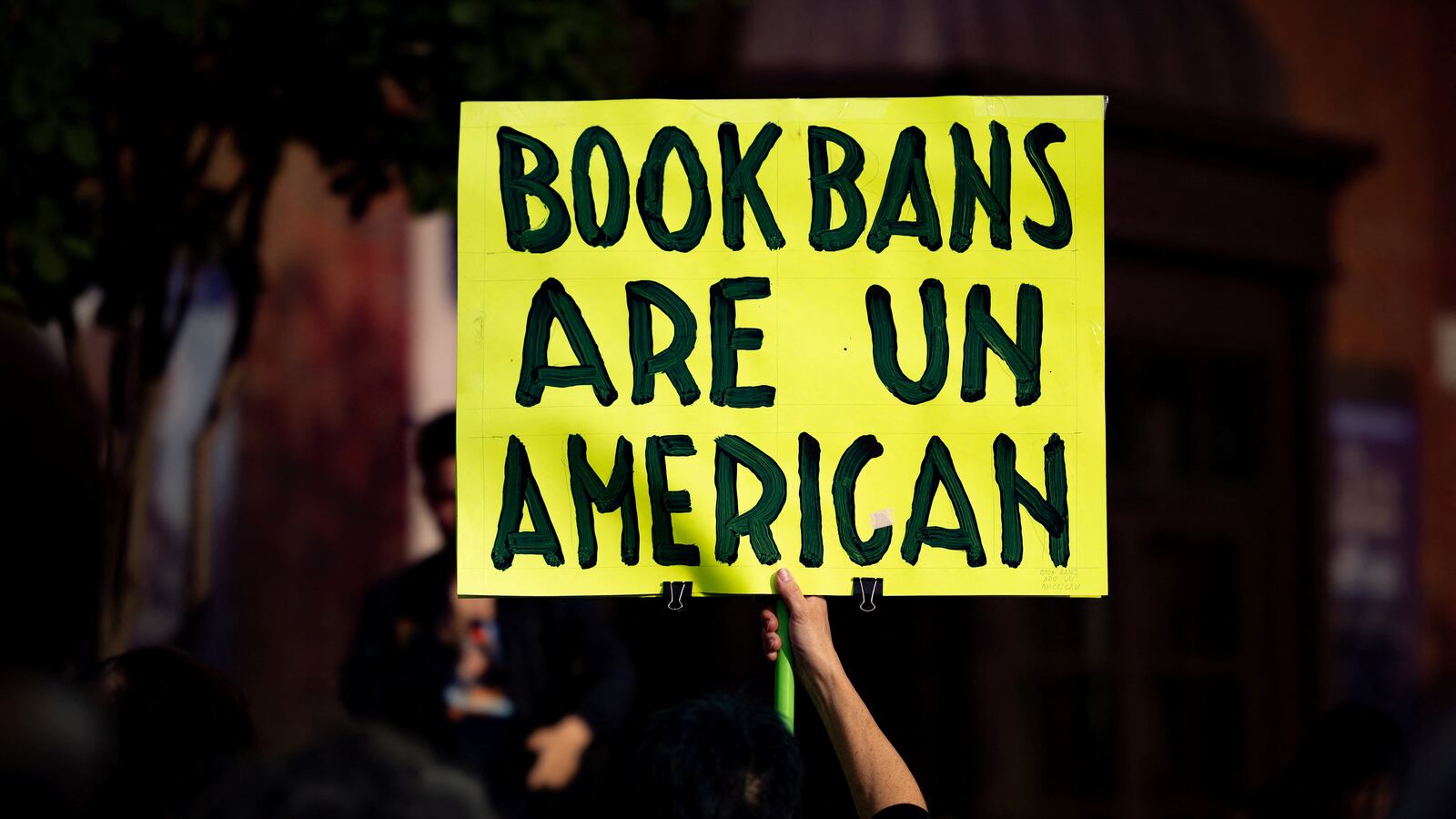 A person participates in a protest against Moms for Liberty.