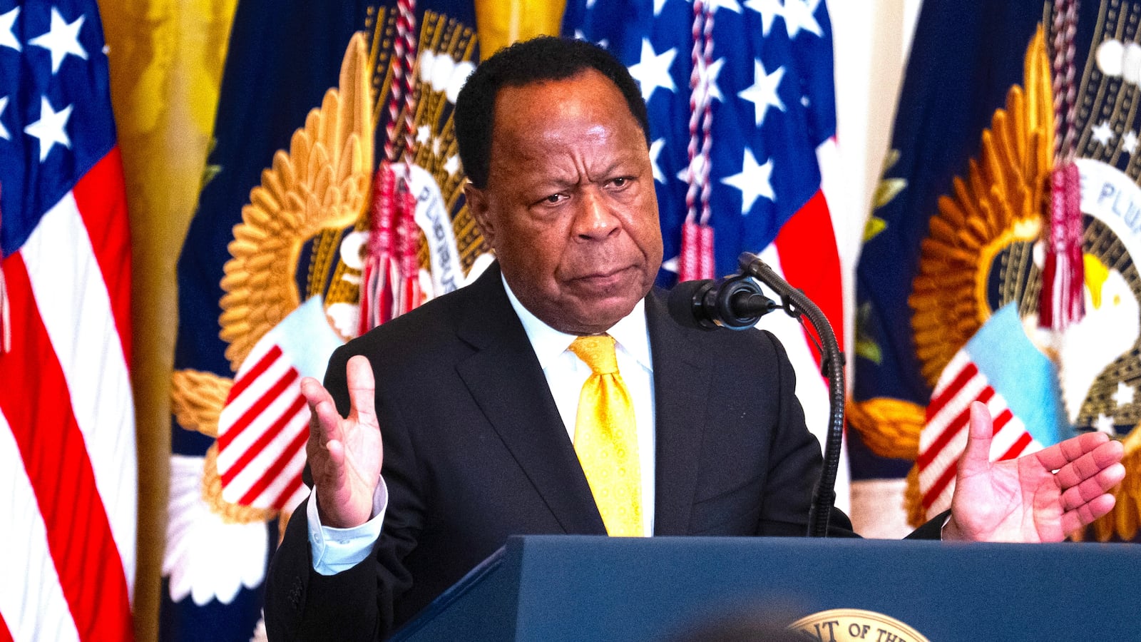 Leo Terrell, chair of the DOJ Task Force to Combat Antisemitism, and President Donald Trump, appear on stage during a Black History Month reception in the East Room of the White House on Wednesday, February 18, 2026.